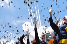 Horrified graduates flee as planes attack crowds with hats.