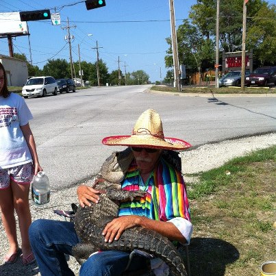 Driving down the street when I see a man sitting on the corner, cuddling with his best friend.
