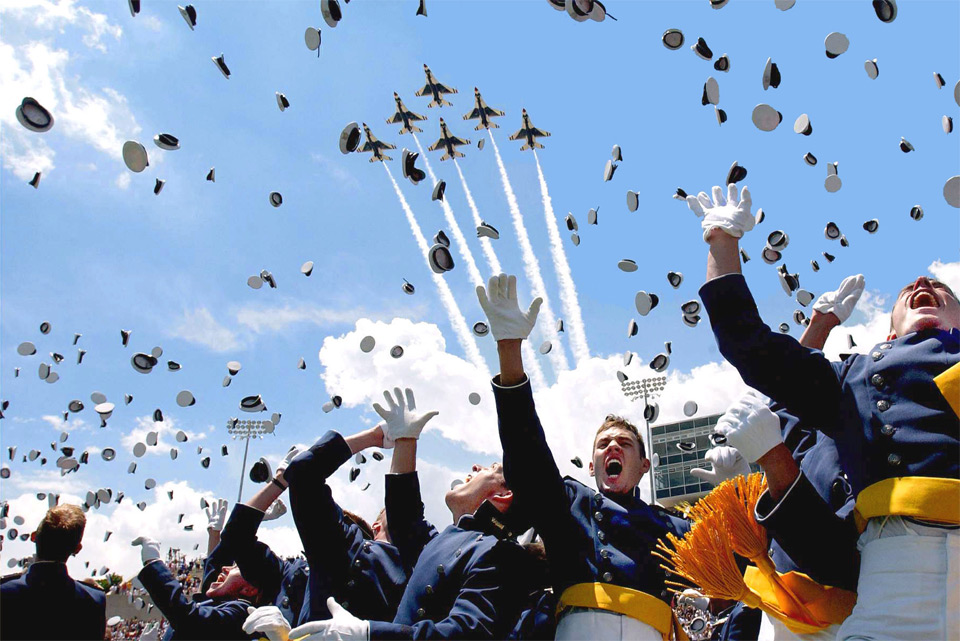 Horrified graduates flee as planes attack crowds with hats.