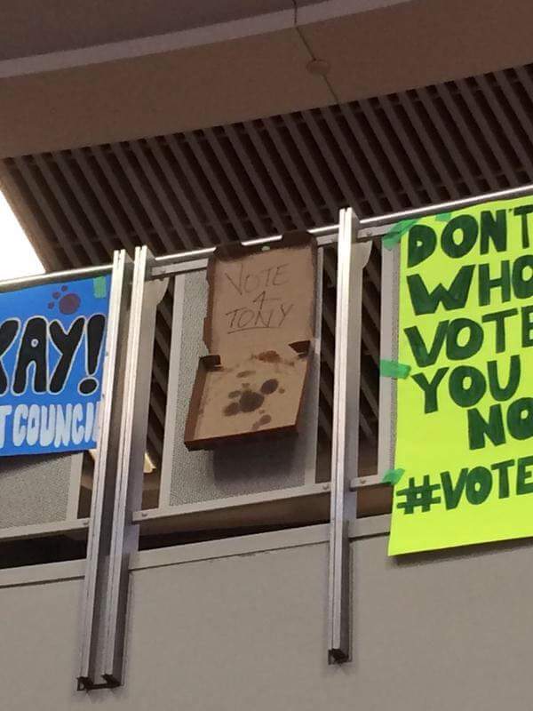 Someone used a pizza box as a poster for student council elections at a high school