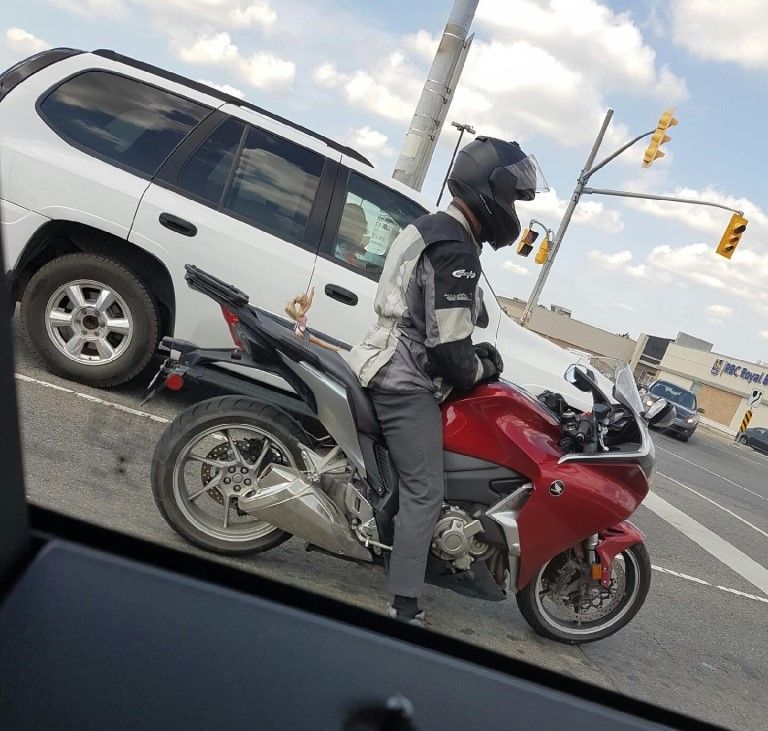 Motorcyclist with a special passenger stopped at a red light