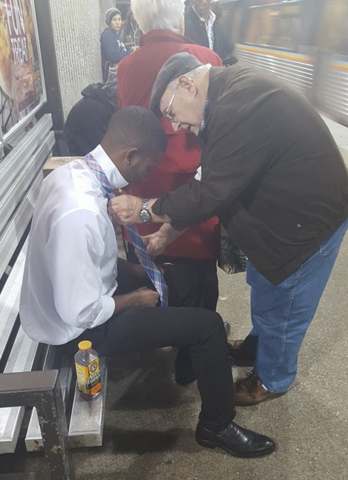 A stranger helping out another stranger struggling with his tie