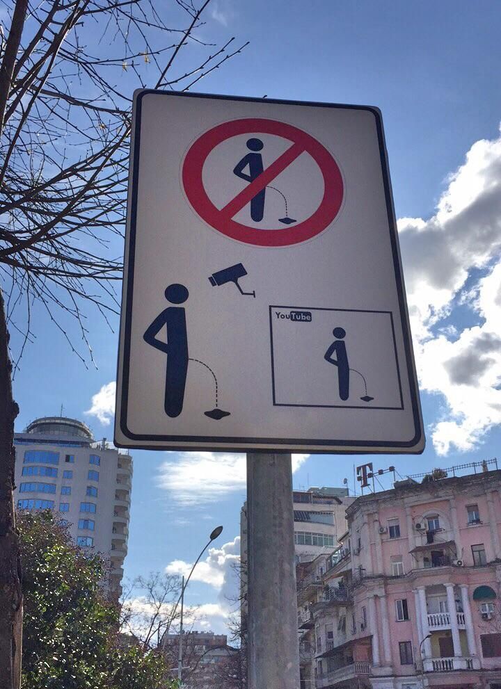Threatening Albanian sign: Pee in the river, get put on YouTube