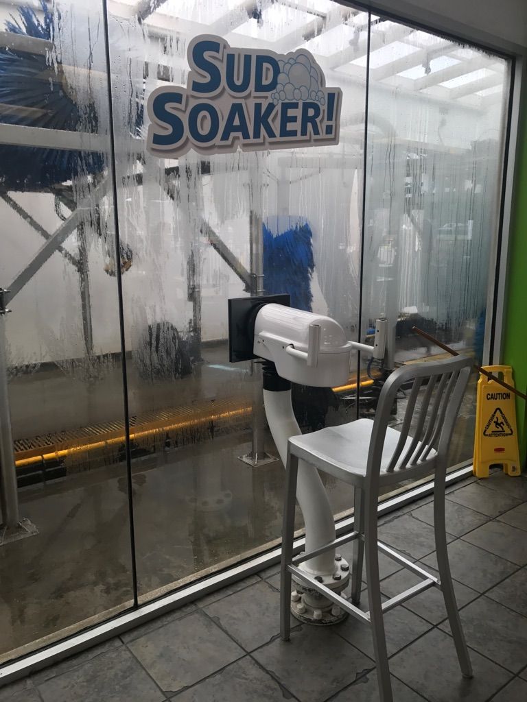 This car wash has a water gun to spray on the vehicles as they are getting cleaned.