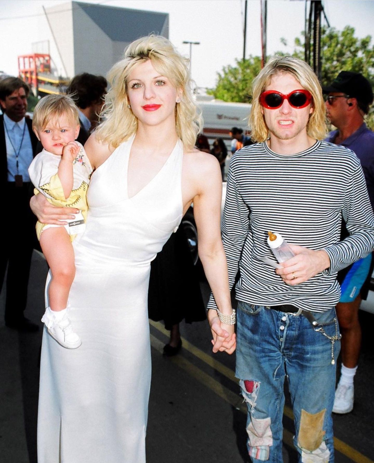 Kurt Cobain looks like a child attending an event with his mother and baby sister.