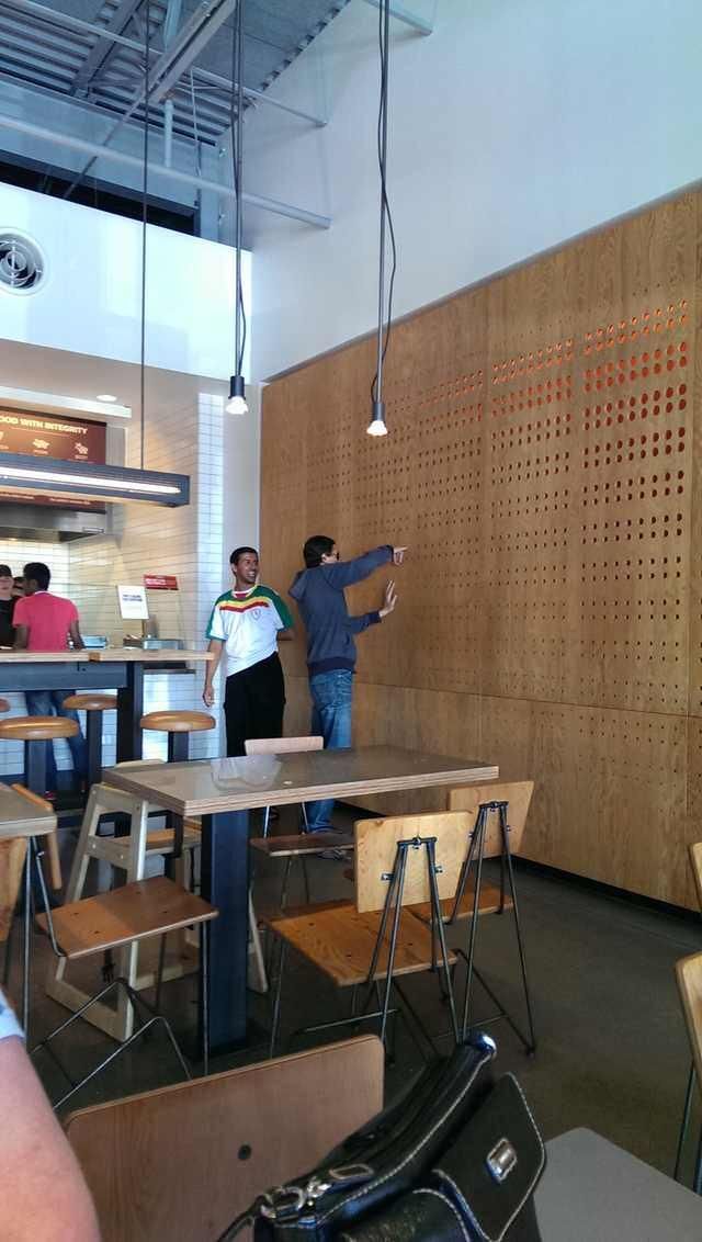 A grown man with his finger stuck in the wall at Chipotle