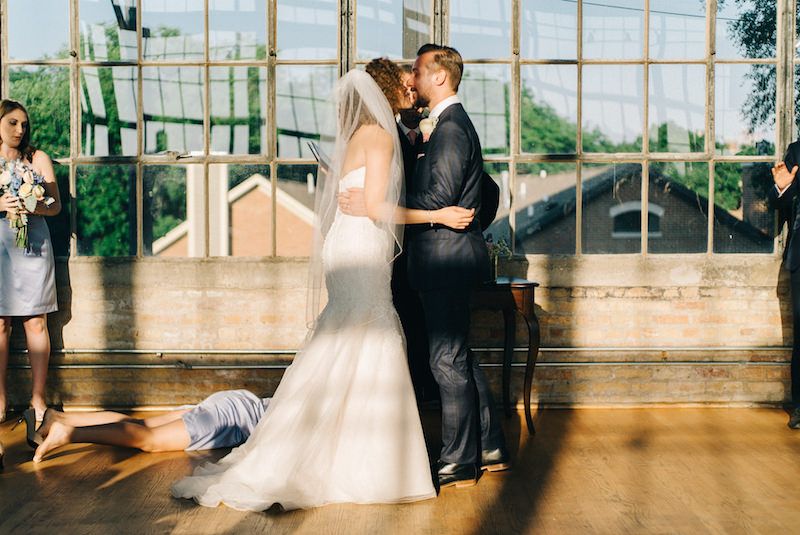 Wedding photographer captures romantic moment between bridesmaid and floor.