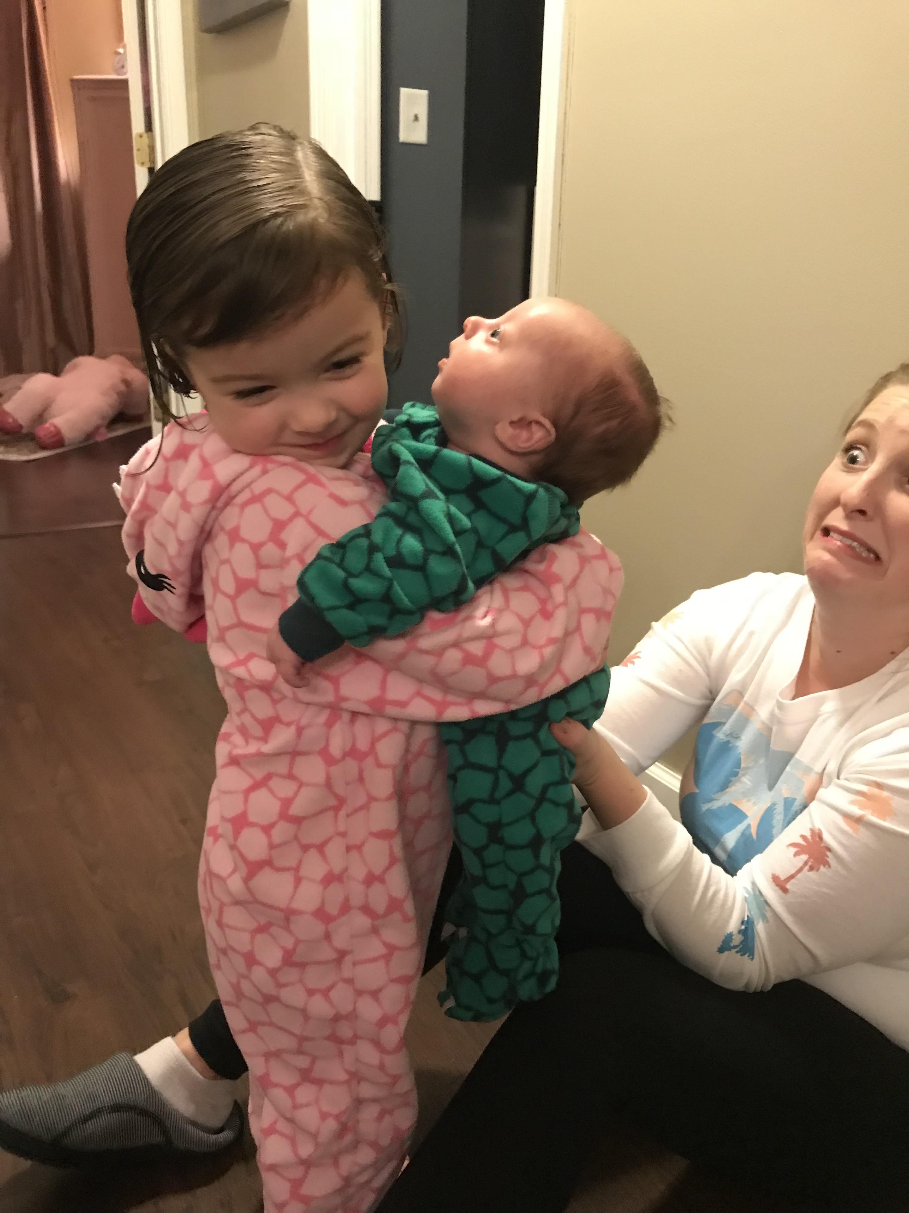 Tried to get a sweet picture of my daughter holding the baby. The real gem is my wife’s panic face