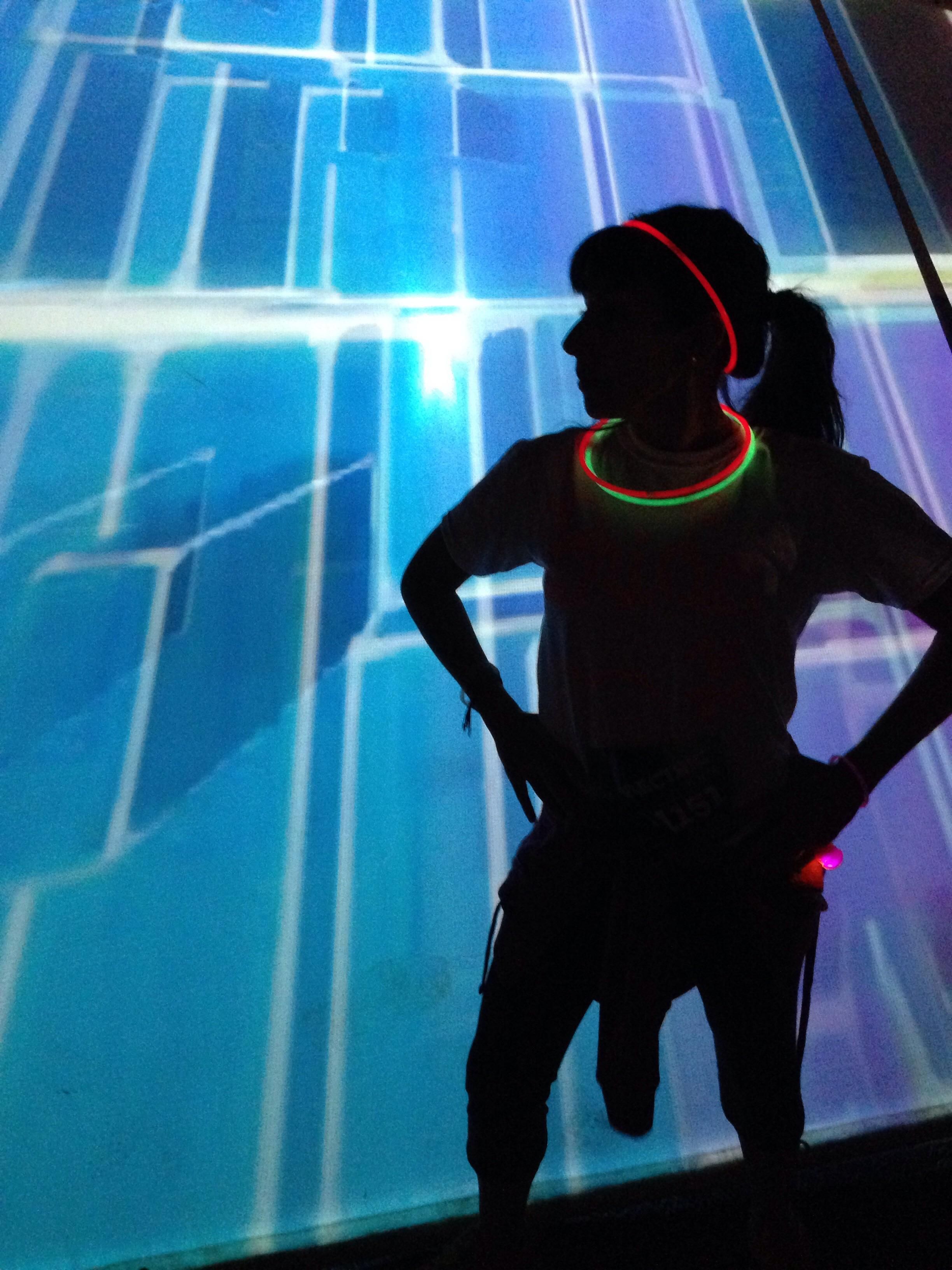 My wife and I recently attended a rave-themed 5K event. I took this picture of her standing in front of a light board...