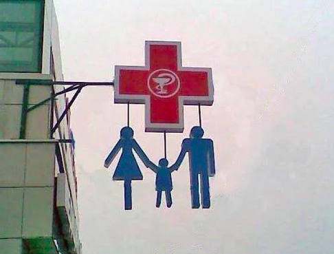 This pharmacy sign with a family hanging from it