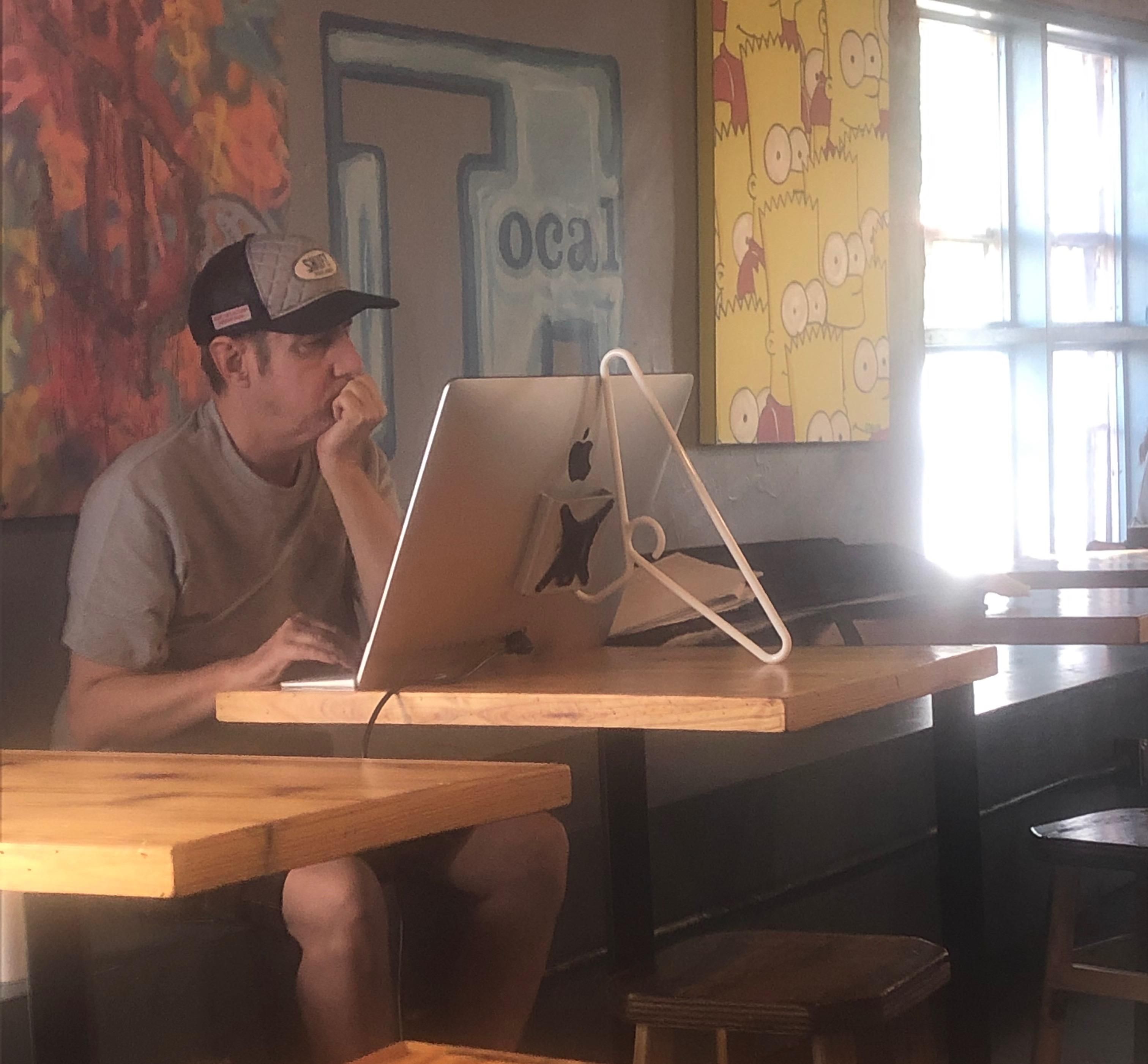 Guy at coffee shop shows off his solution to the $999 Apple stand.