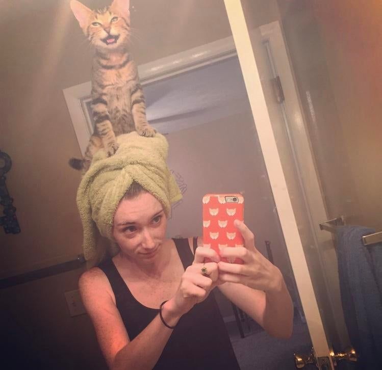 My friends cat likes sitting on her head