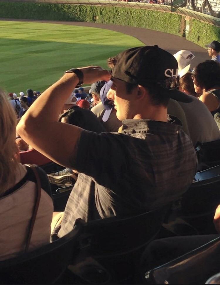 This man has a hat and sunglasses and still using his hand to block the sun