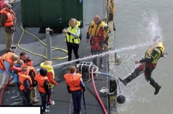 Kids playing with water hose during Coast Guard demonstration