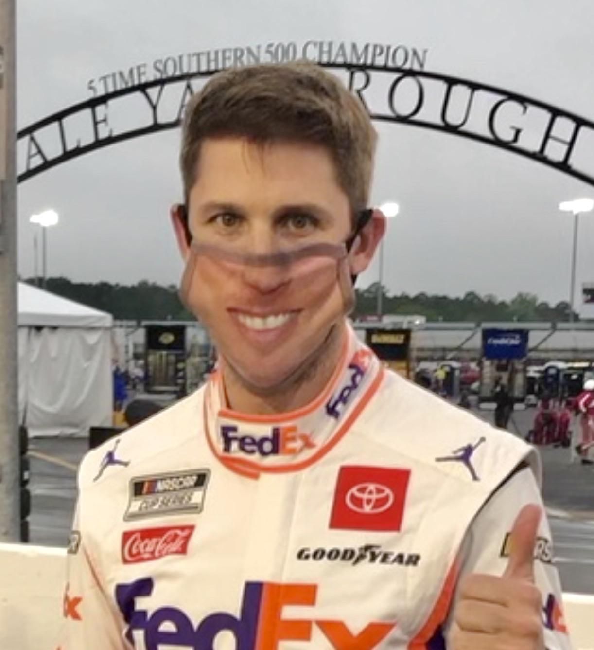 NASCAR driver Denny Hamlin wears a mask with his own face on it, before the race.