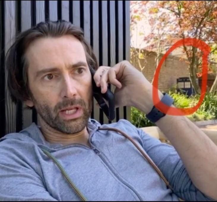 This picture of David Tennant talking into an empty phone case with a TARDIS in the background.