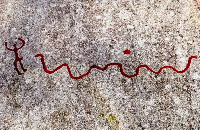 3000 year old petroglyph of a man running away from a snake.