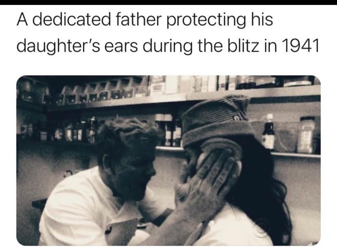A dedicated father protecting his daughter's ears during the blitz in 1941