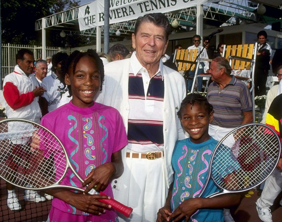 Venus and Serena Williams pose for a photo with a local drug dealer