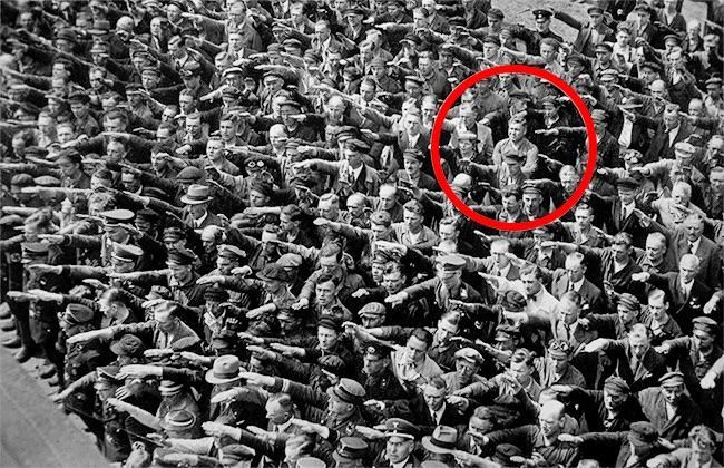 Man brings a red hula hoop to a Nazi Rally in Berlin,