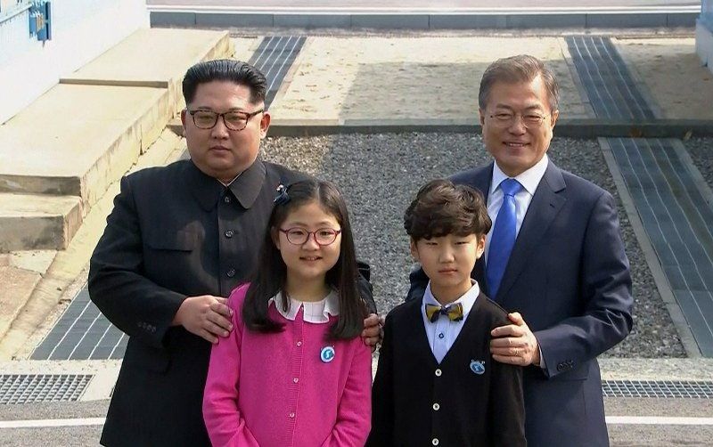 Korean gay couple celebrates their marriage with a family photo, circa. 2017