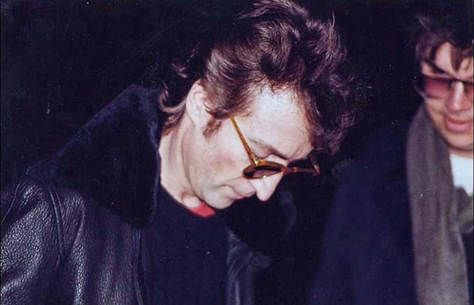 John lennon happily signs a very large fans autograph, 1980