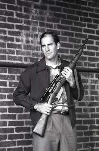 Lee Harvey Oswald poses with his new rifle, c. 1963